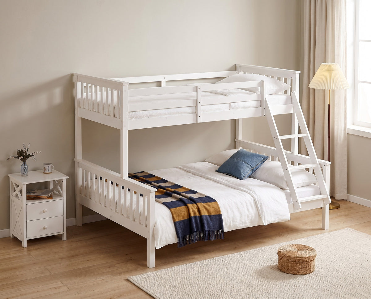 Thornbury white triple bunk bed seen from the double bottom bunk end, with bedside table and floor lamp