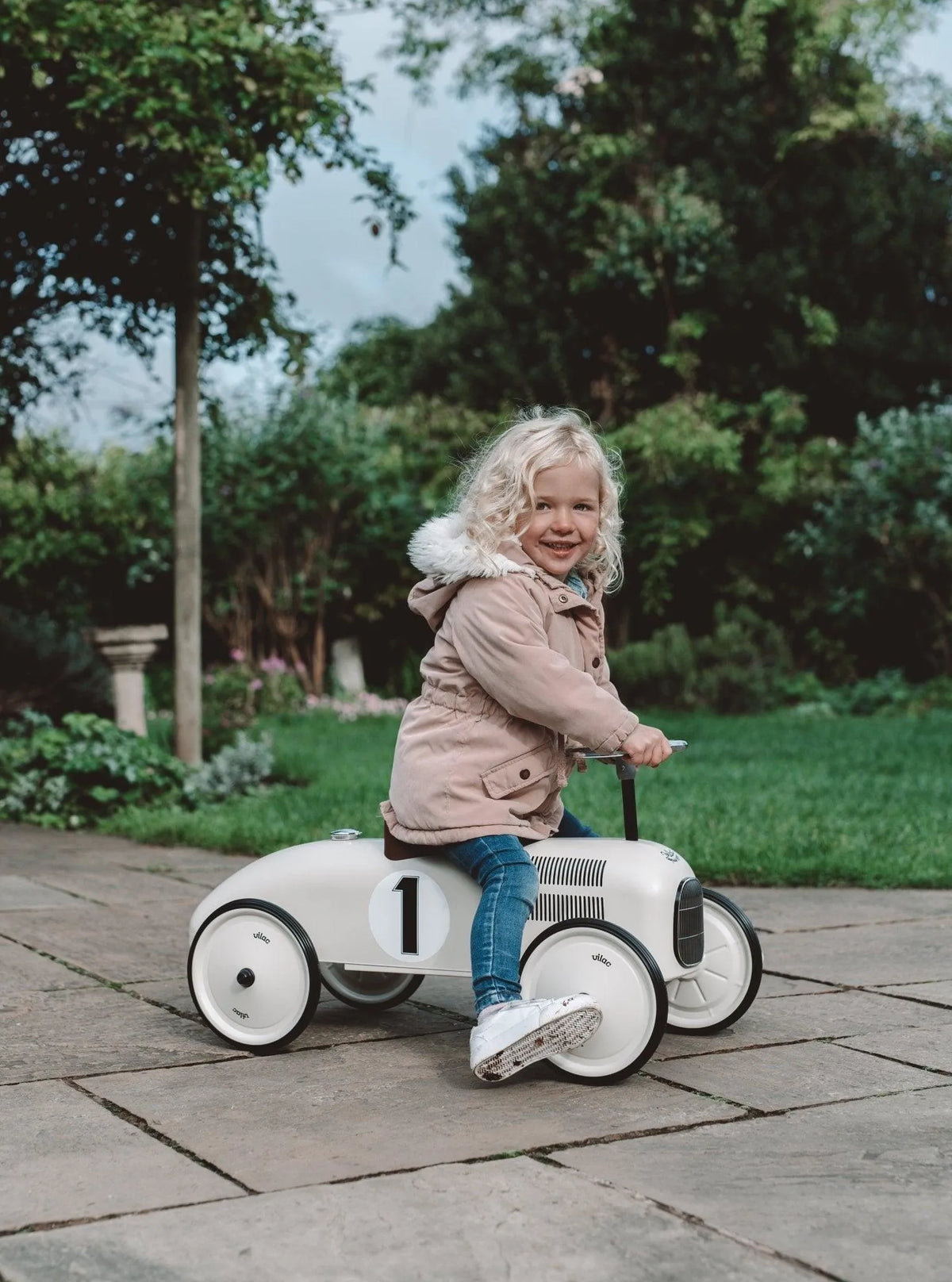 Toddler riding the Vilac metal car outside