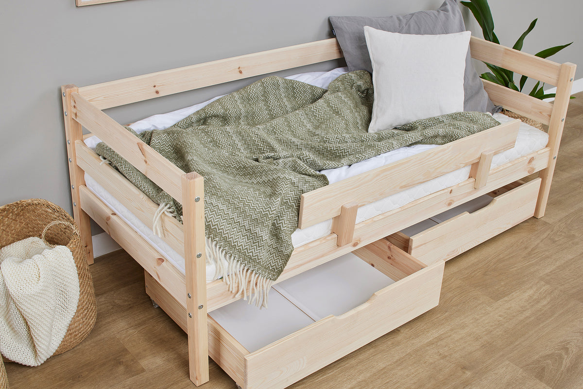 Tarn Shorty daybed in natural pine with the safety rail and a drawer open, angled view
