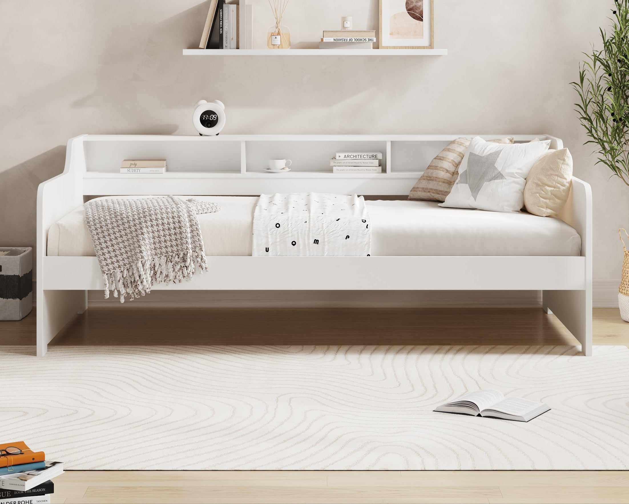 white-bed-with-pillows-and-a-blanket-in-a-room-with-a-shelf-and-plant-featuring-millie-jones-branding