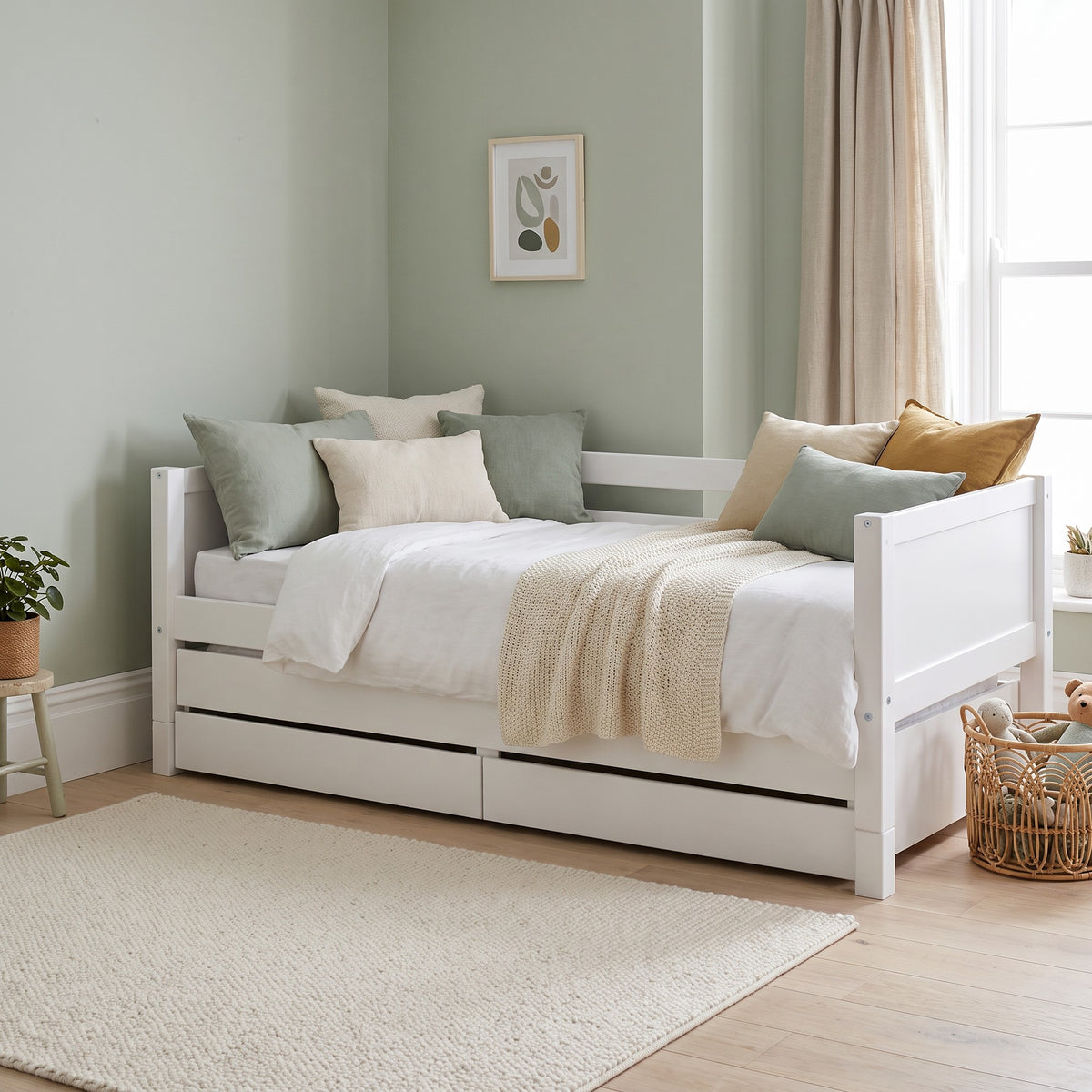 Ashdown white daybed styled as a sofa, with the trundle and drawers pushed in underneath
