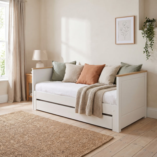 Ashwell white and oak daybed styled as a sofa, with the underbed drawer closed