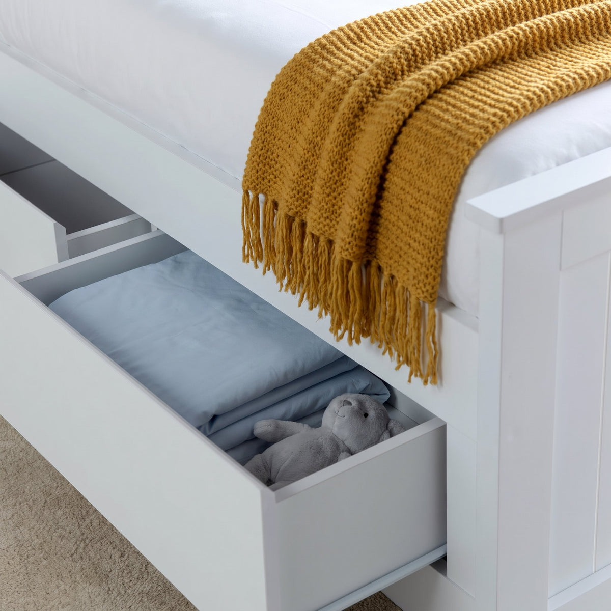 Hartley white bed drawer pulled open with folded bedding inside