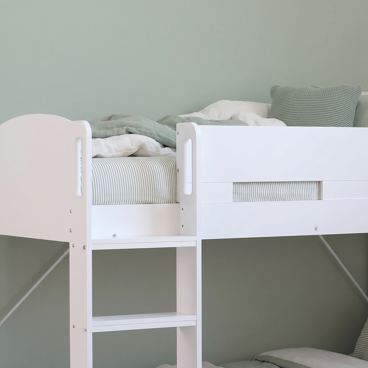 Top bunk of the white Ripley bunk bed, with the ladder and the hand-holds in the end panel