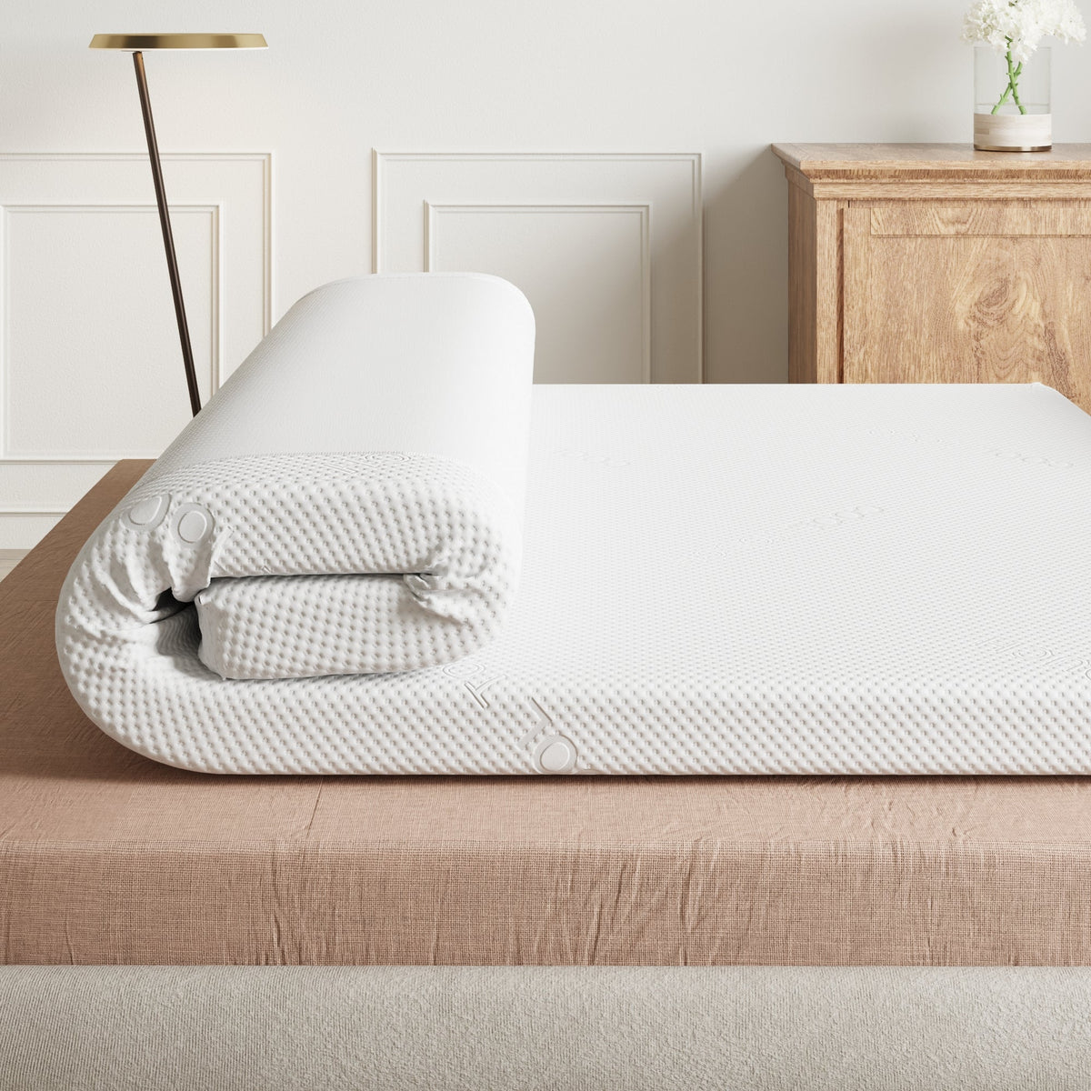 Millie & Jones Titan 5cm Firm Mattress Topper being unrolled on a bed