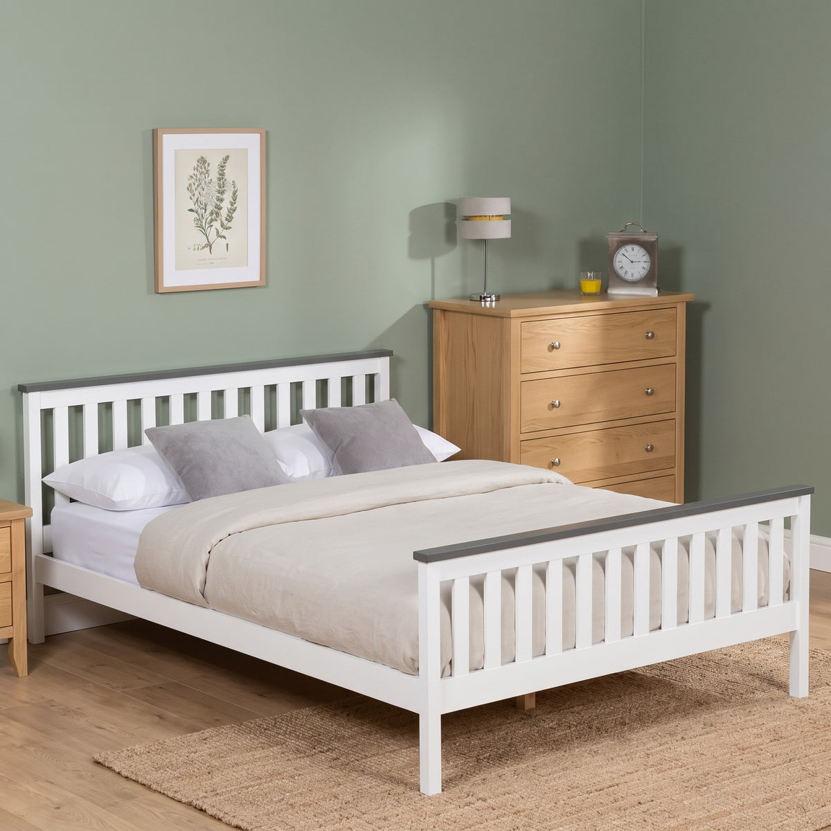 Nami white wooden bed with grey top caps on the headboard and low foot end, made up as a double in a sage green bedroom