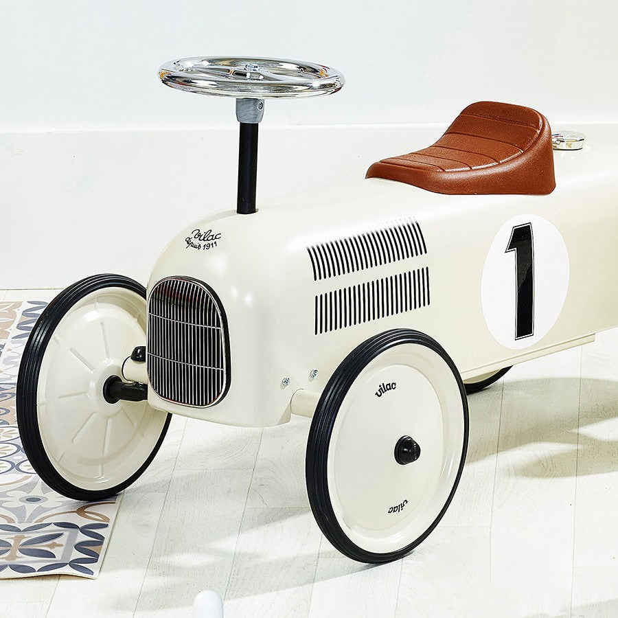 Vilac metal ride-on car in Cream indoors